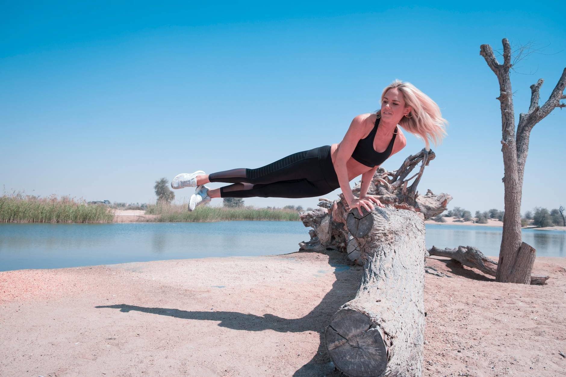 Woman in a dynamic yoga warrior pose outdoors.